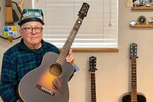 Guitar repairman Dan Erlewine holding an acoustic guitar