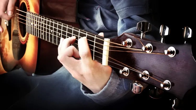 a guitar playing demonstrating a chord