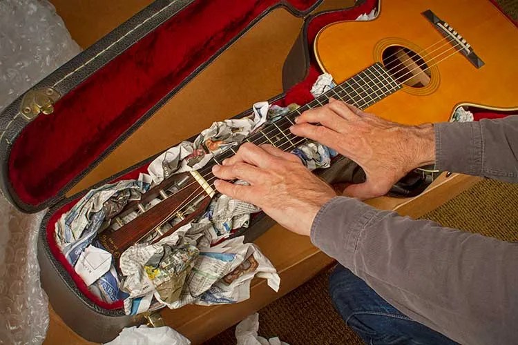 Preparing an acoustic guitar for shipment.