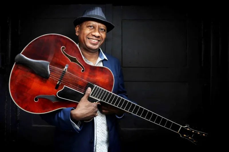 Ron Jackson smiling with an archtop guitar