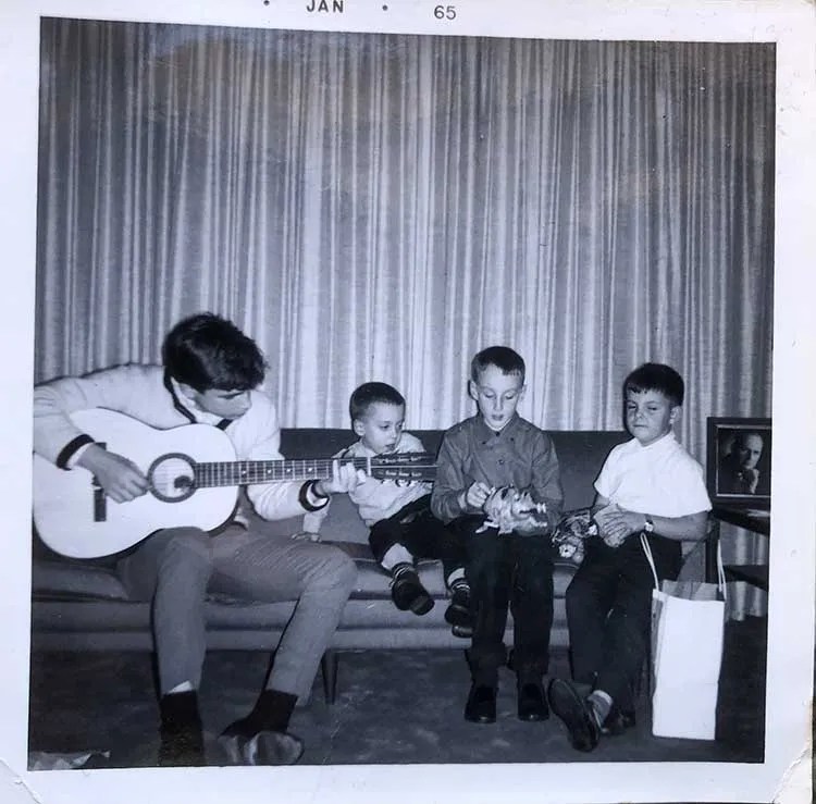 A young Steve James playing guitar for family members.